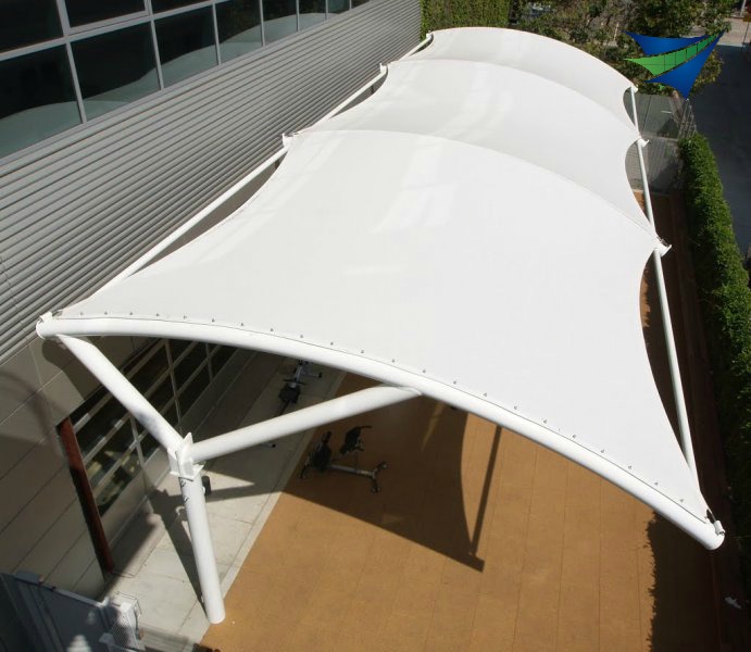 Tensile fabric used in a tension fabric structure for a walkway covering